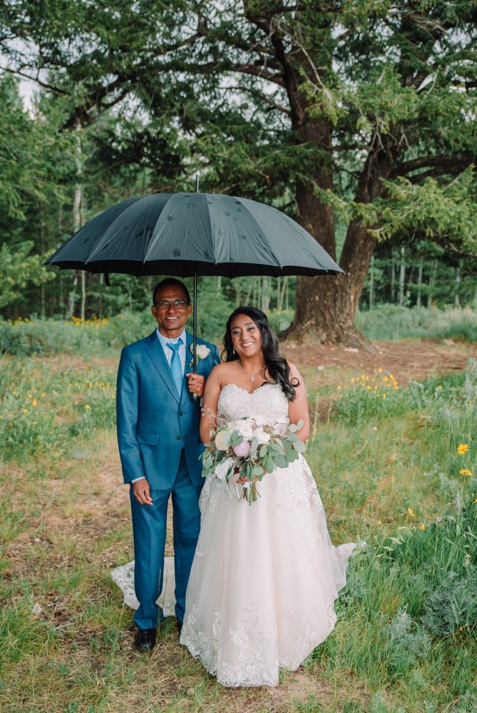 bride and father under umbrella