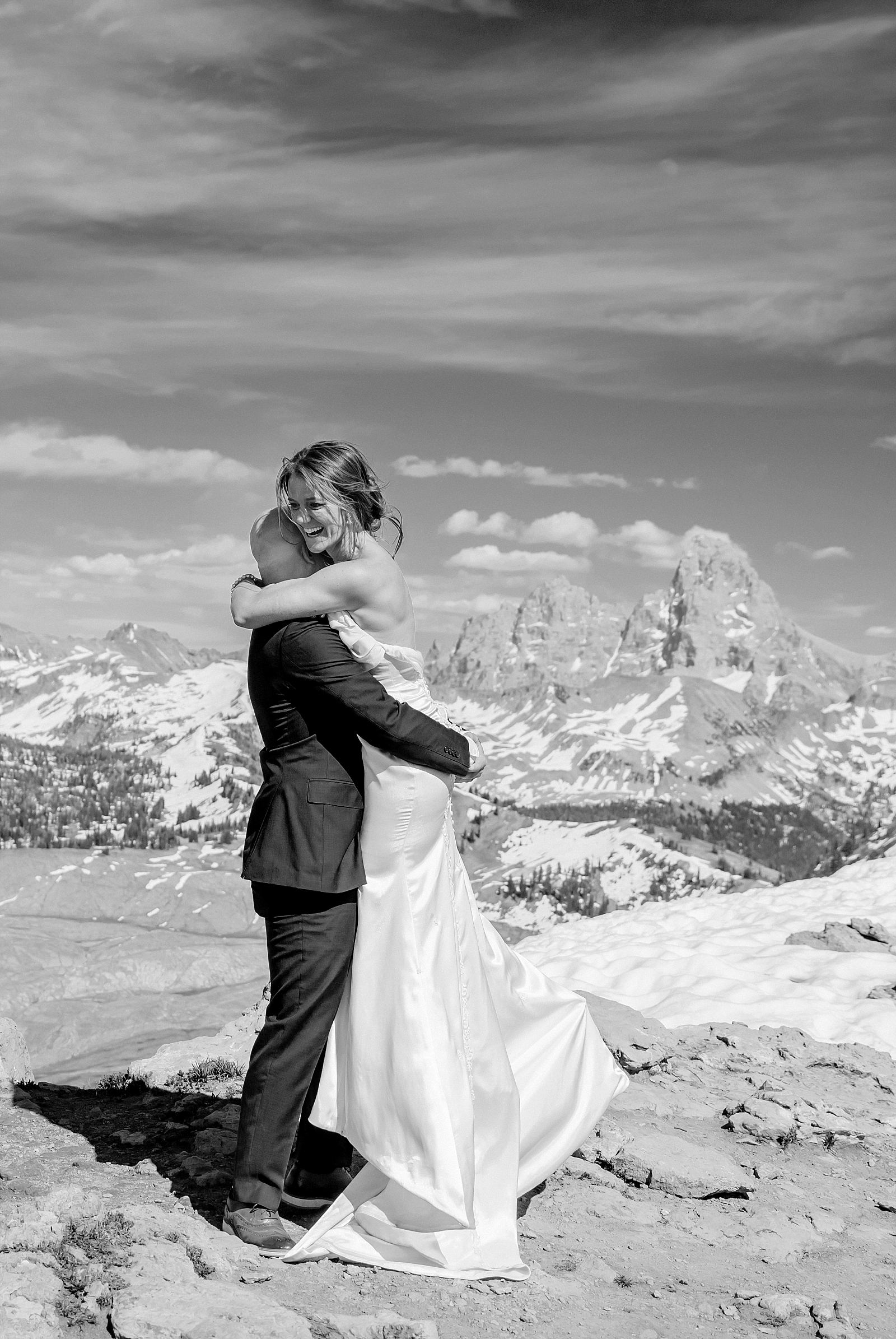 bride and groom hug on top of mountain