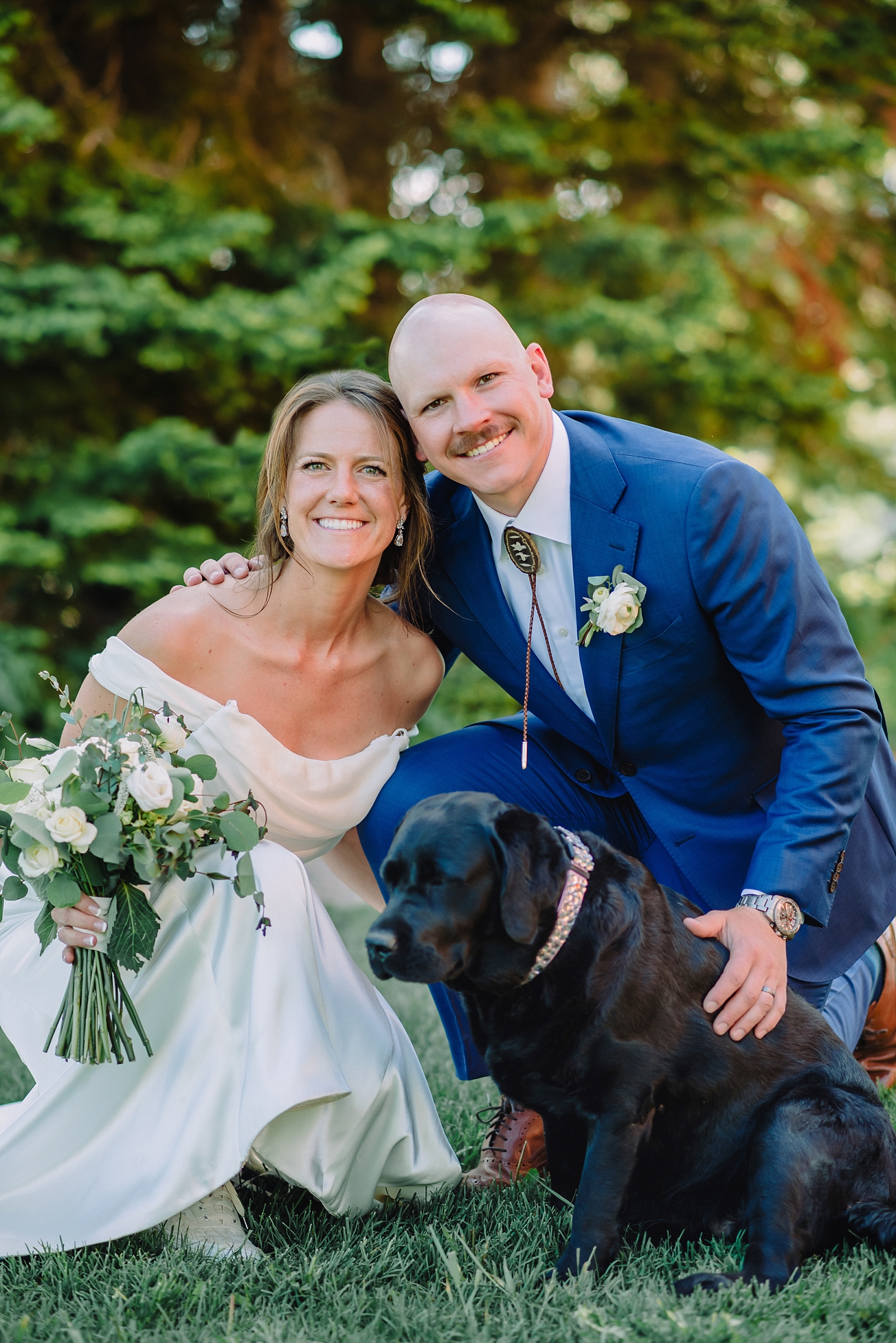 bride and groom with their dog on wedding day