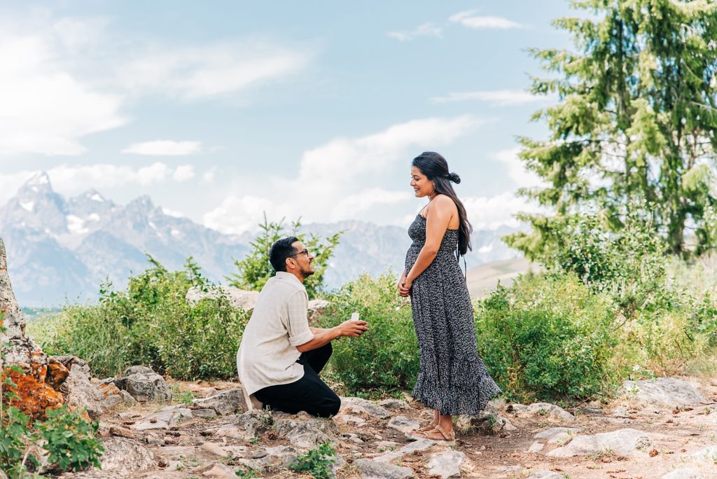 boyfriend proposes to girlfriend with tetons in the back