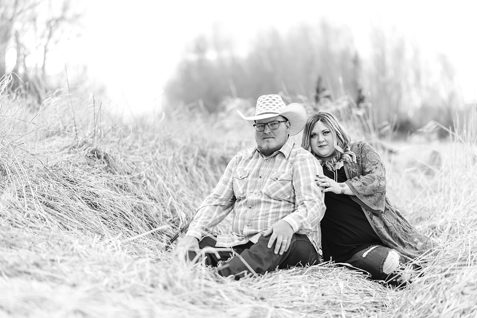 couple sits together in tall grass