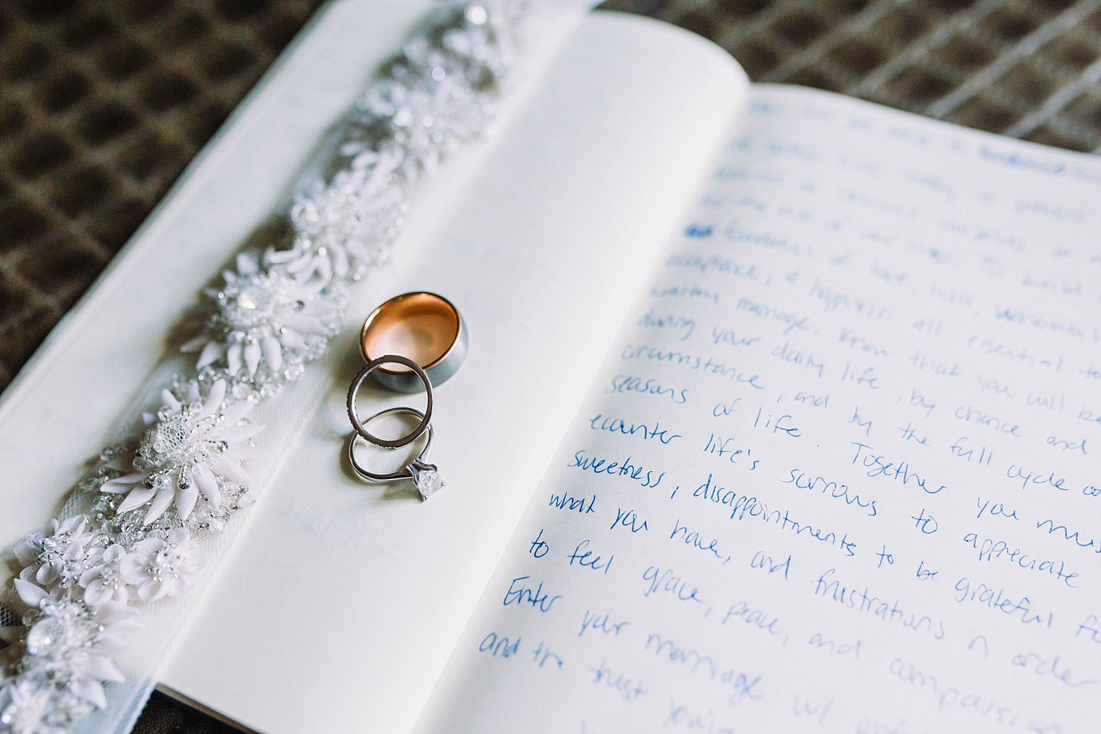 vow books for wedding ceremony with wedding details including bridal belt and rings