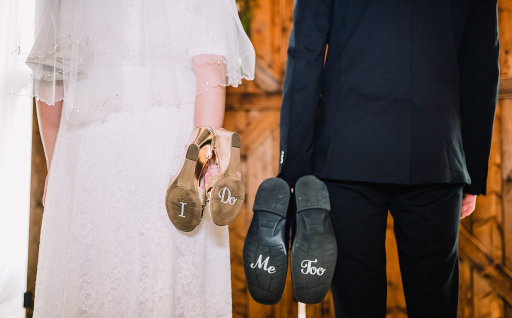 bride and groom holding wedding shoes making their wedding special