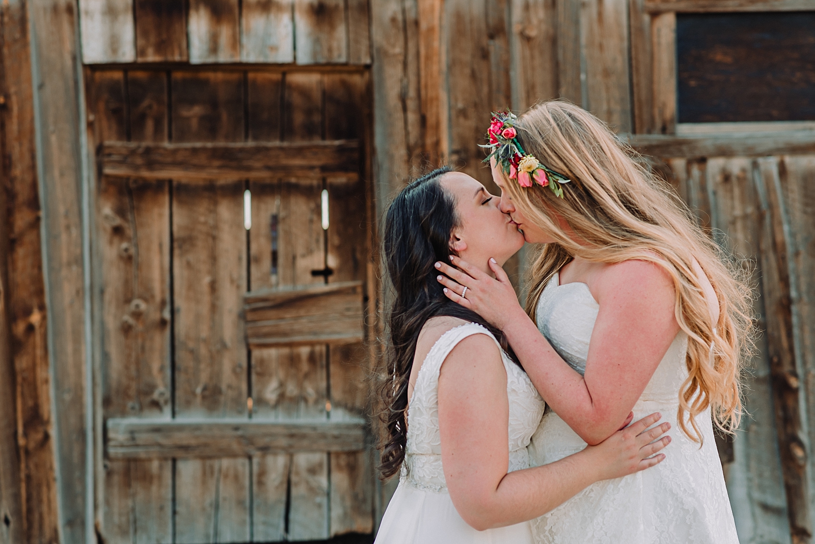 two brides kiss in wedding ceremony