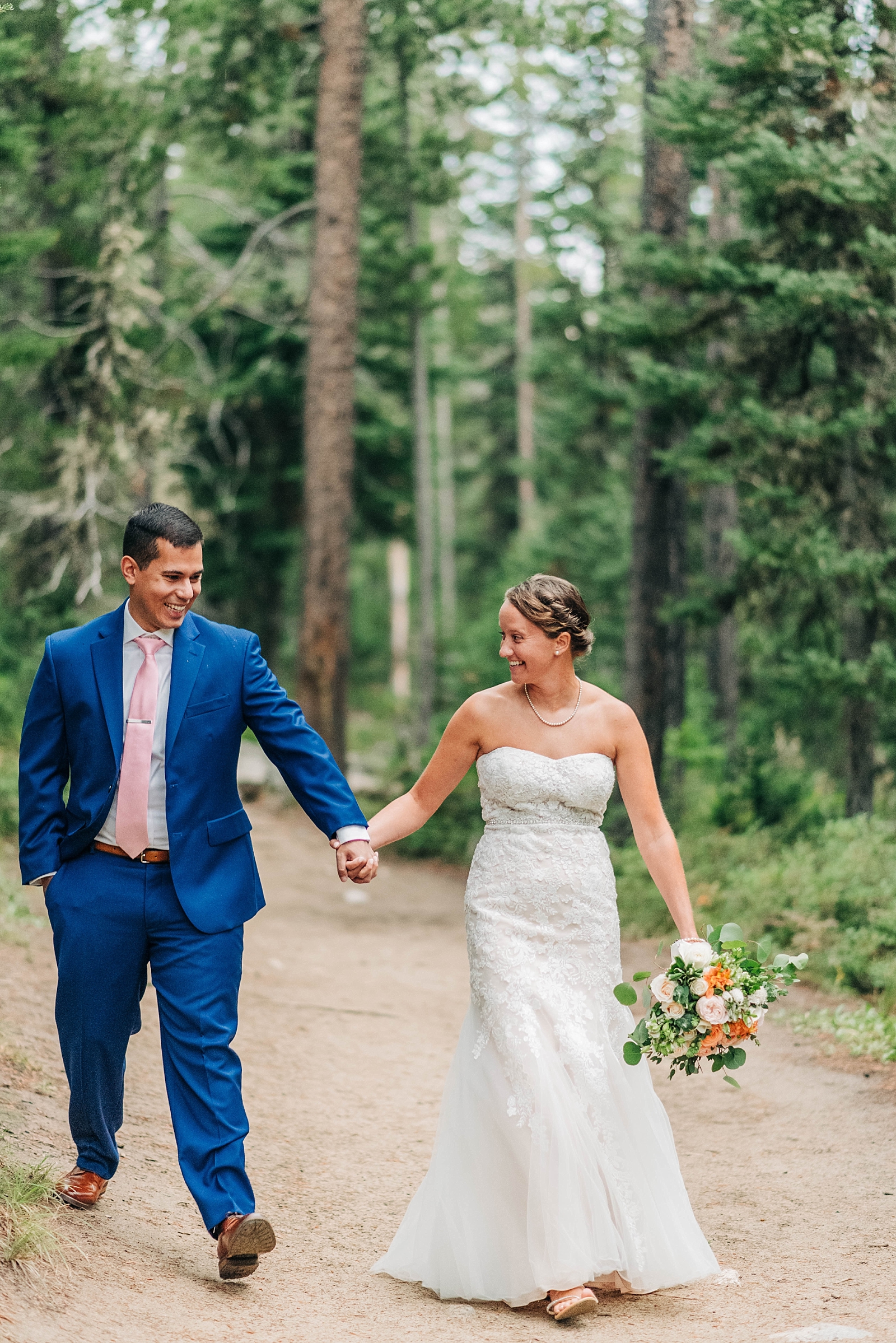 bride and groom walk on leigh lake trail