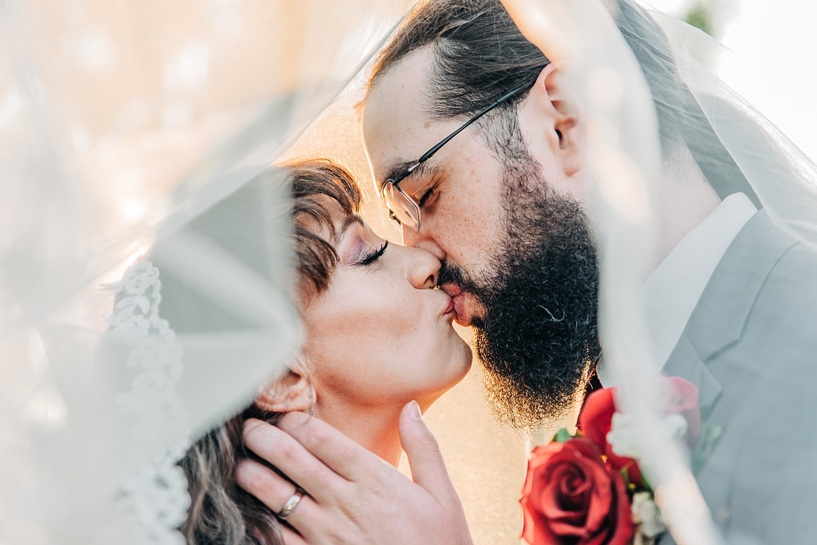 bride and groom wedding portraits veil kisses
