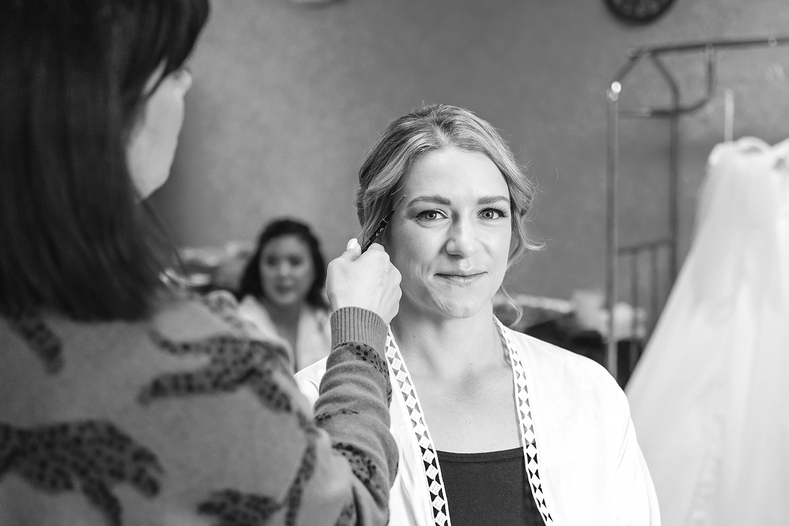 bride getting makeup done on wedding day
