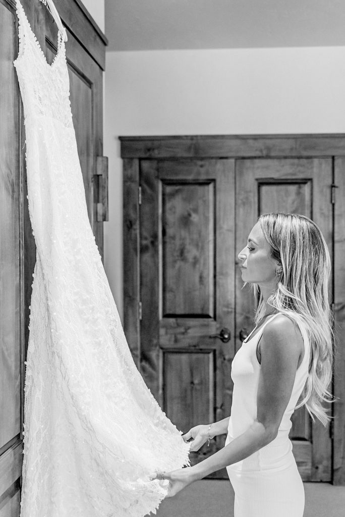 Bride looks at wedding dress on her Wedding Day during getting ready photos at Snow King Resort