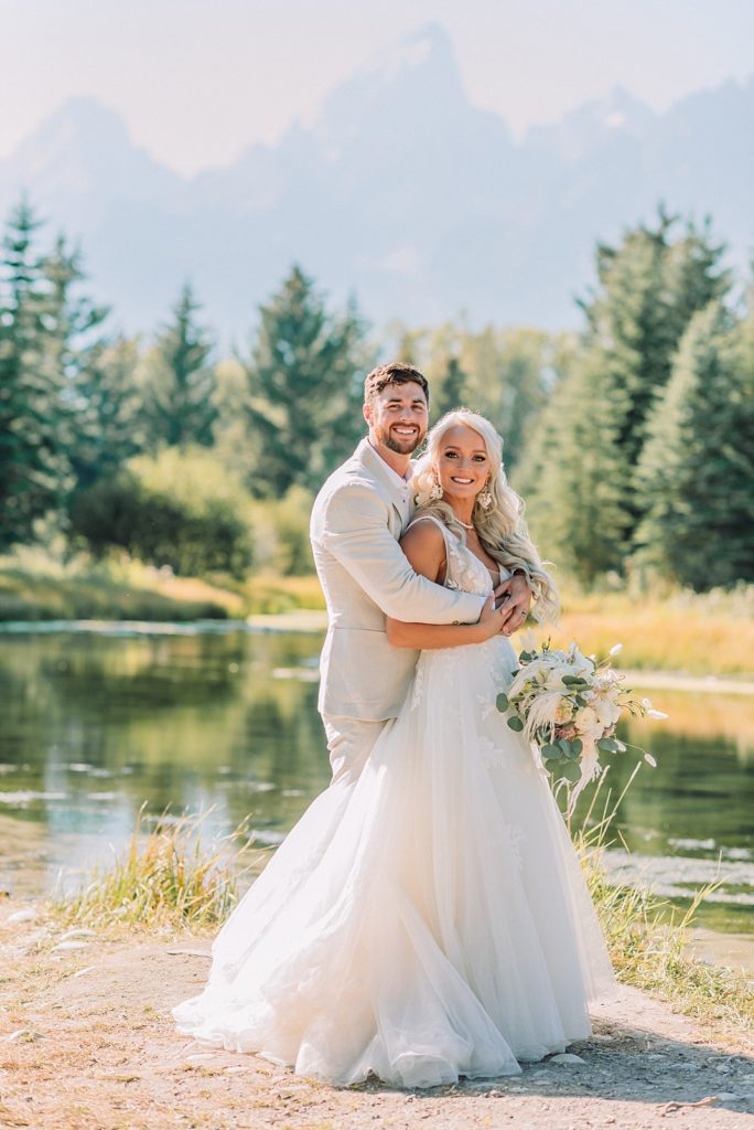 Bride and groom take wedding portraits in front of the Teton mountains