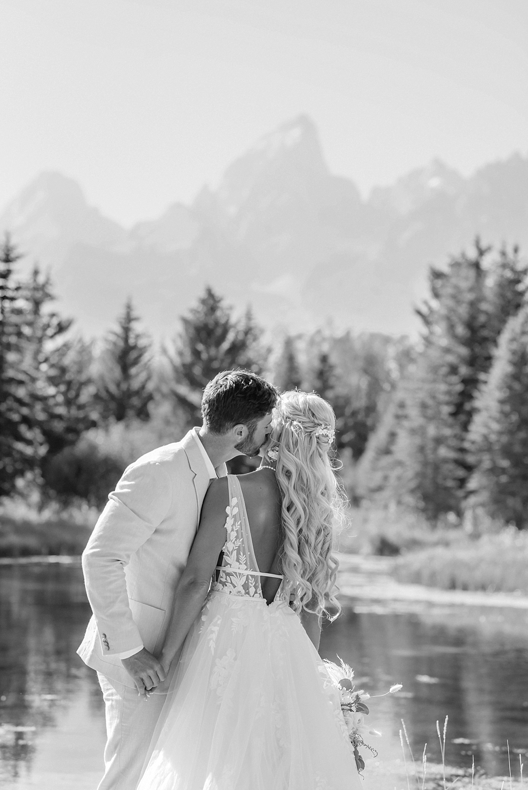 Bride and groom take wedding portraits in front of the Teton mountains