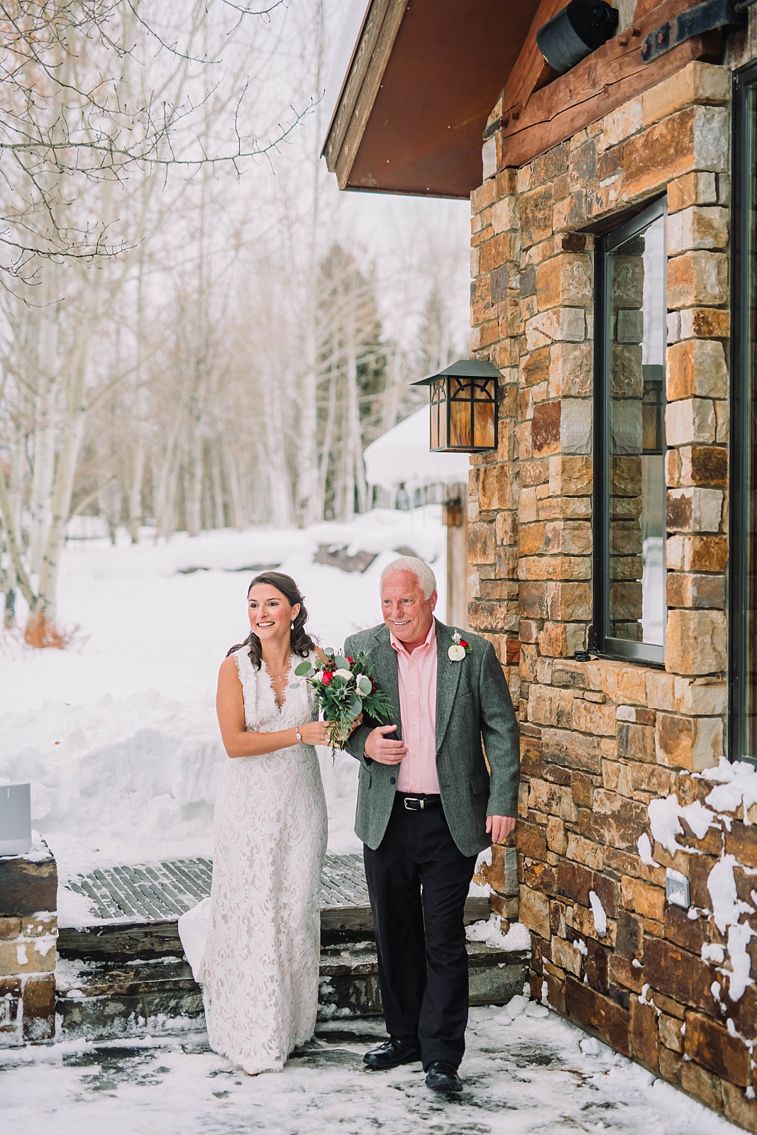 father and daughter walk down the aisle in outdoor winter wedding ceremony