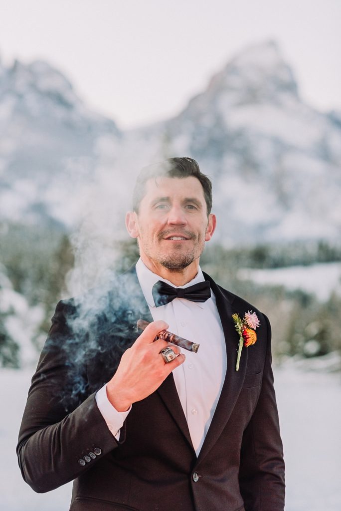 groom smokes cigar after wedding