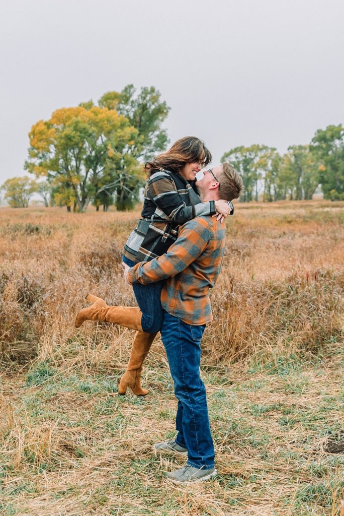 Man picks up woman during engagement session