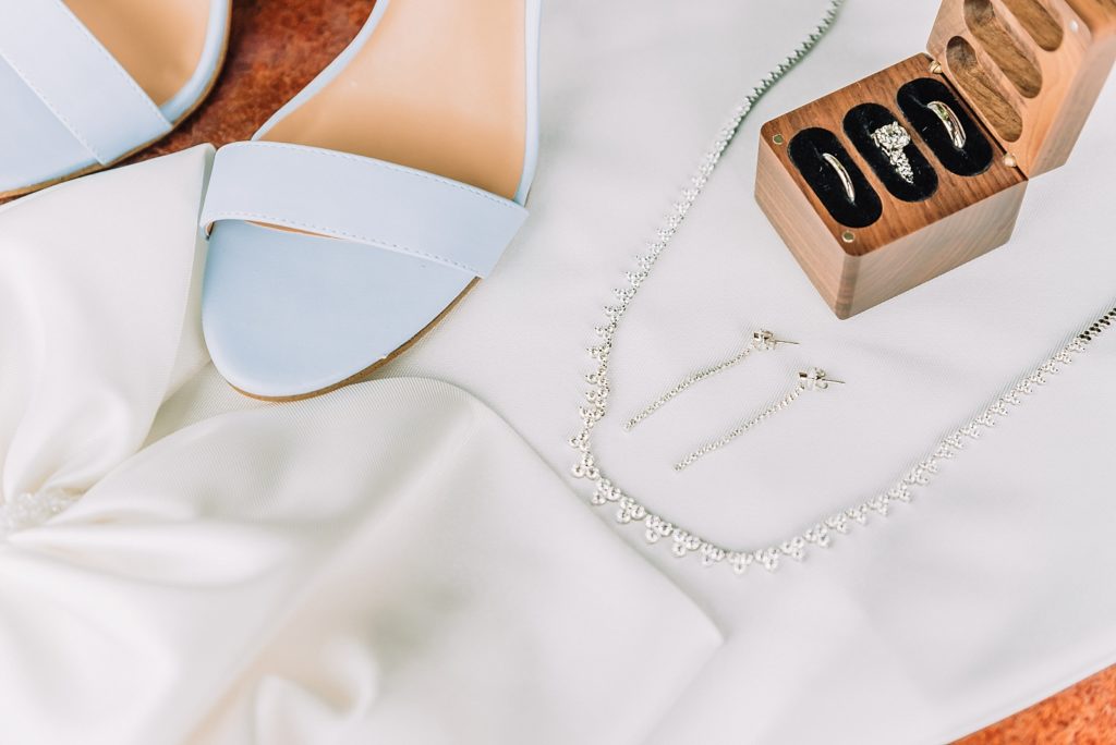 dreamy wedding details with bride's shoes, rings and jewelry, dress bow