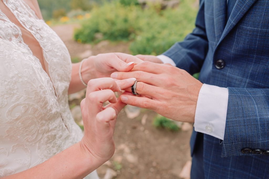 bride and groom exchange rings during wedding tree micro-wedding ceremony