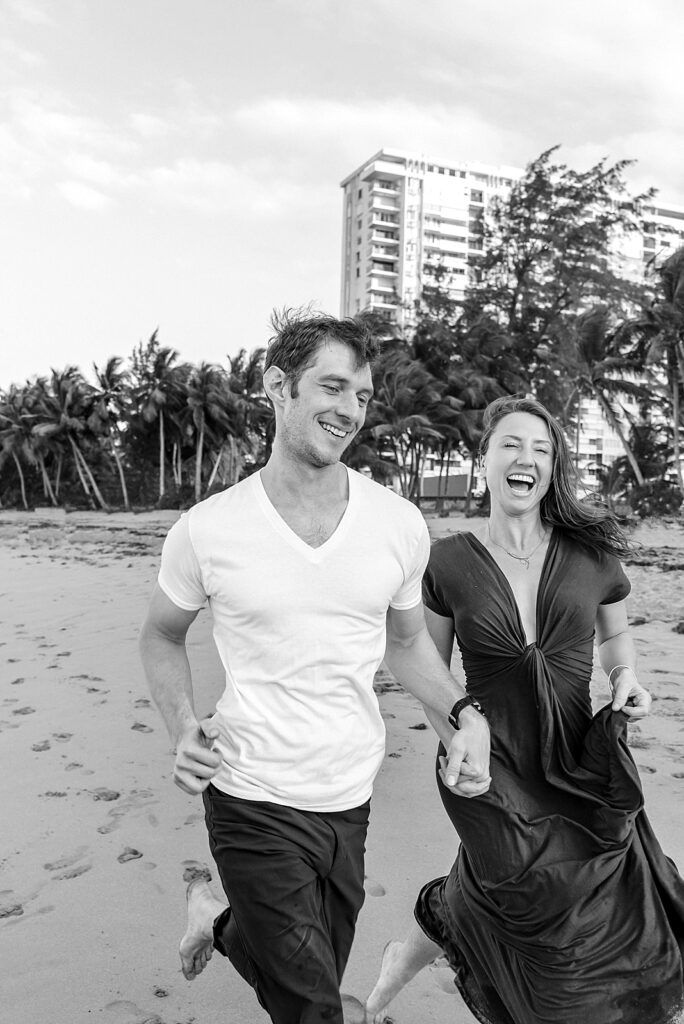 couple laughing as they run on the beach