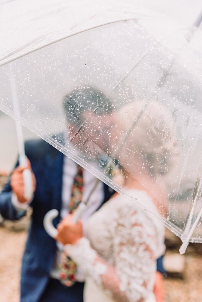 bride and groom with umbrella on wedding day, jackson hole wedding photographer, jenny lake wedding portraits, grand tetons