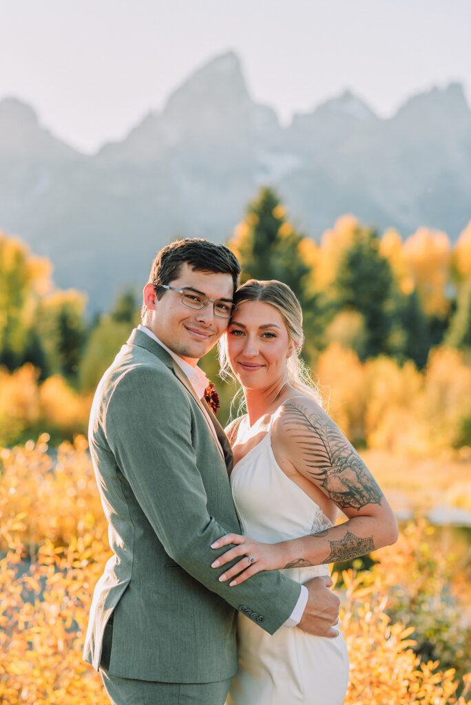 wedding couple posing in front of the grand teton mountains