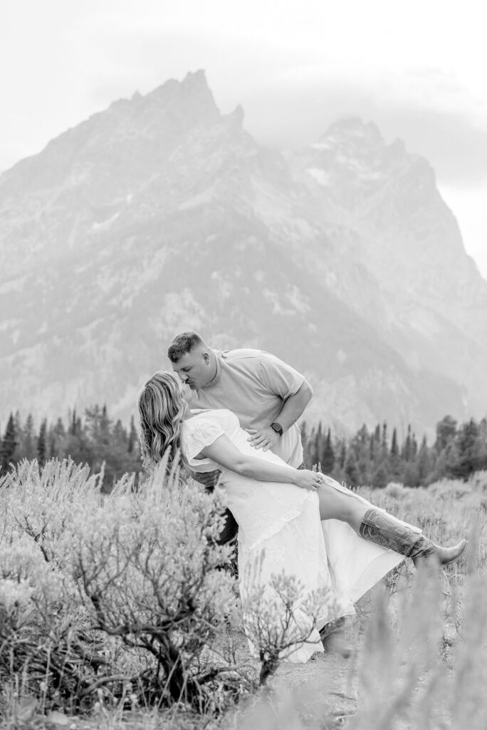 engaged couple stands in front of the Teton Mountains in romantic pose