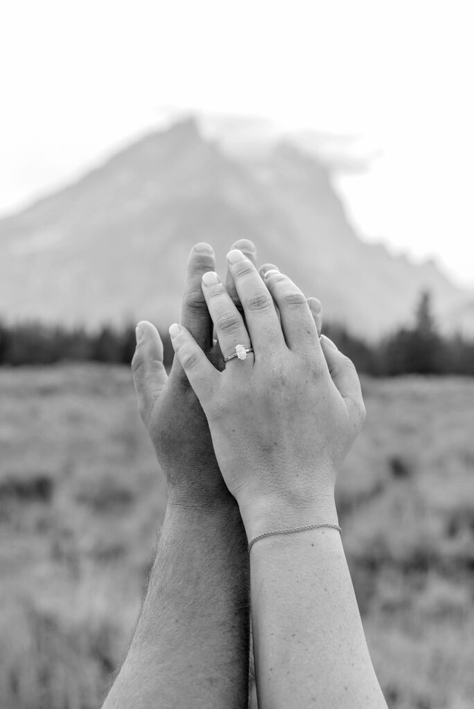 engaged couple stands in front of the Teton Mountains in romantic pose