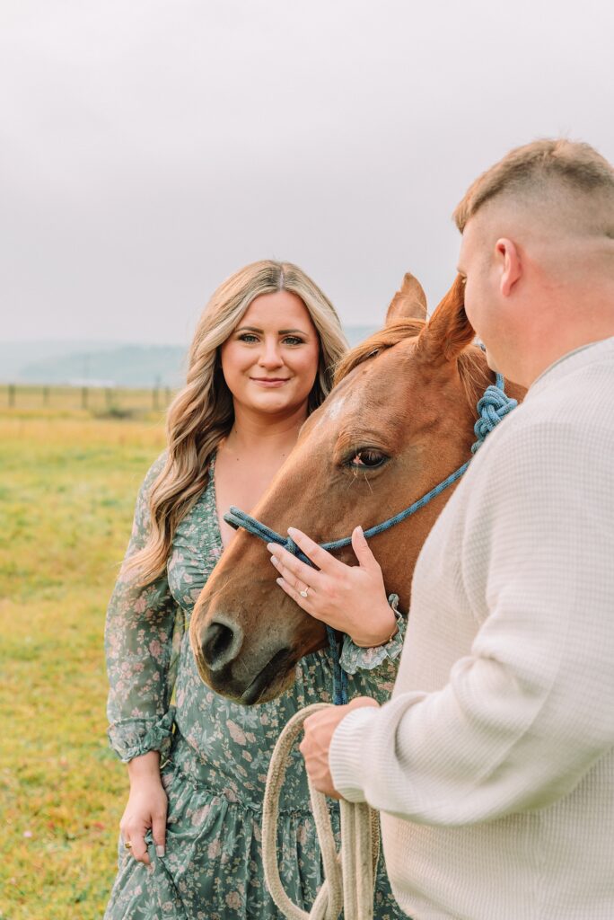 engaged Couple poses with horses at Diamond Cross Ranch