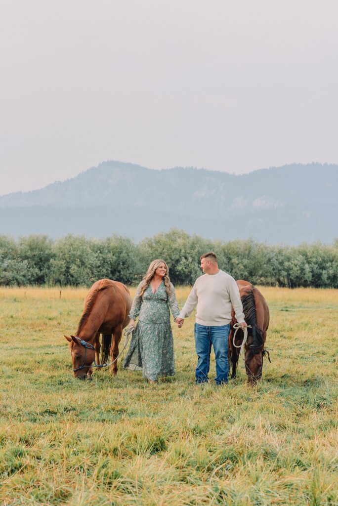engaged Couple poses with horses at Diamond Cross Ranch
