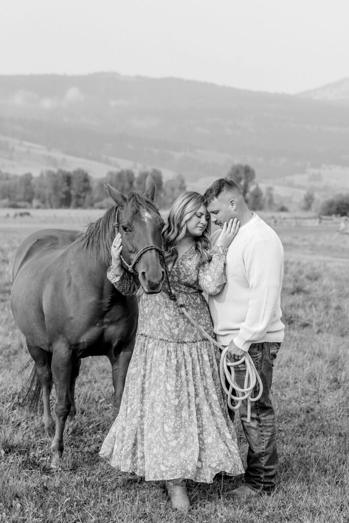 engaged Couple poses with horses at Diamond Cross Ranch