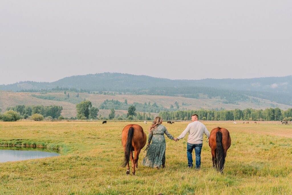 engaged Couple poses with horses at Diamond Cross Ranch