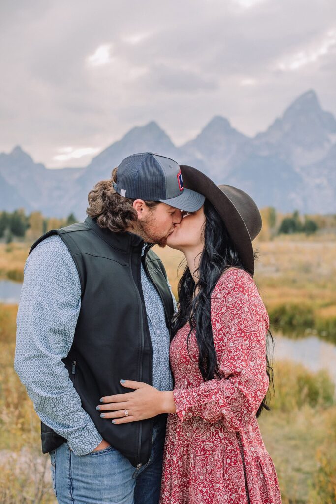 couple kisses at schwabacher landing during engagement photos