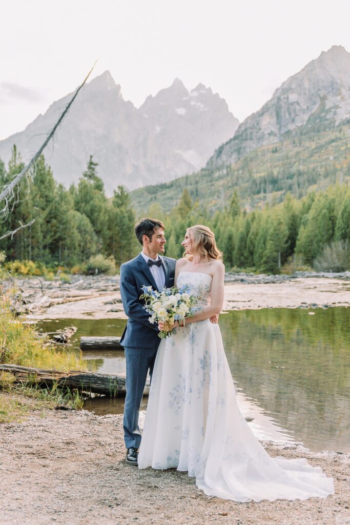 wedding couple pose in front of the Grand Teton mountain range