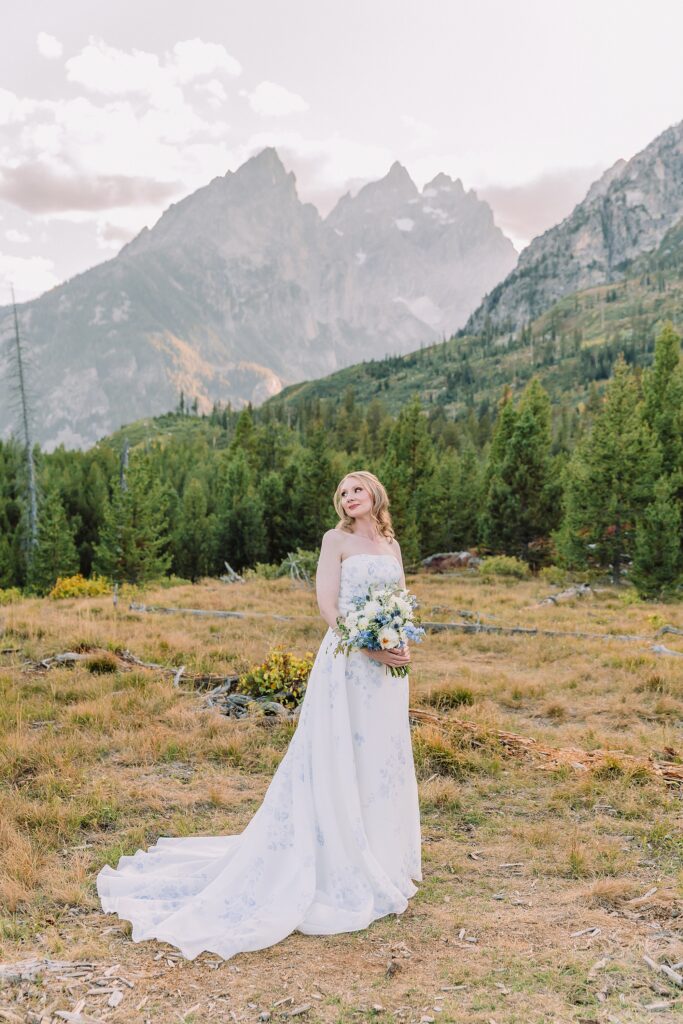 bride poses in wedding dress at String Lake in Jackson Hole