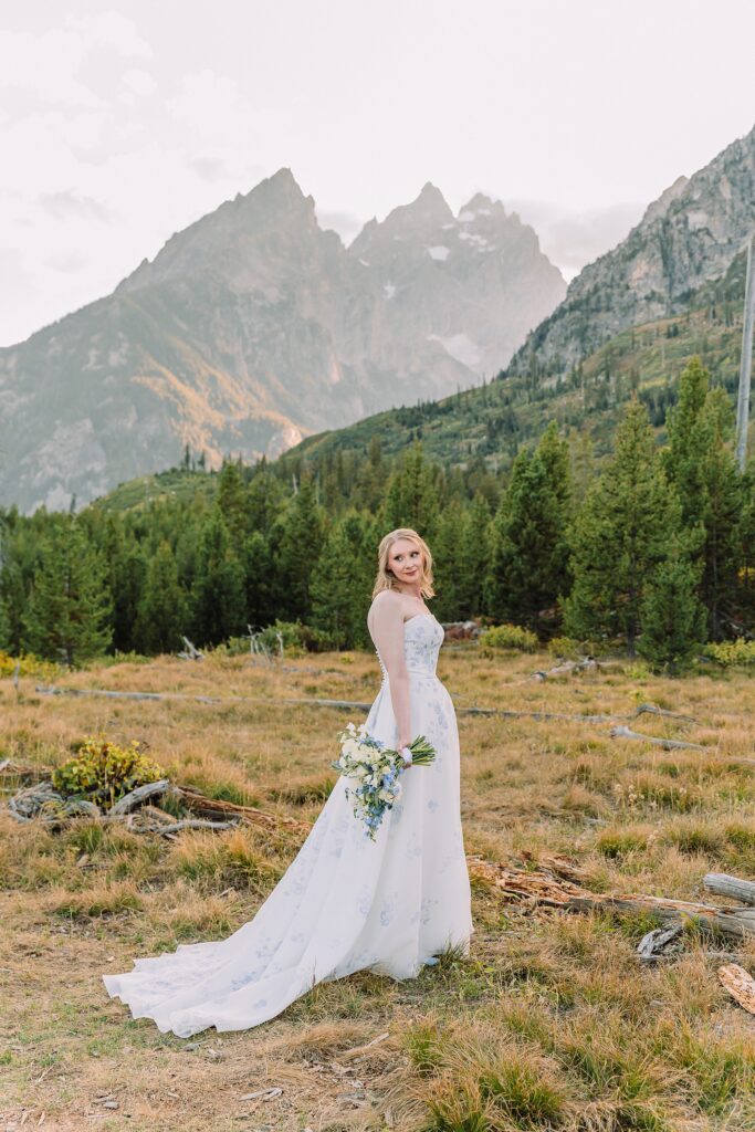 bride poses in wedding dress at String Lake in Jackson Hole
