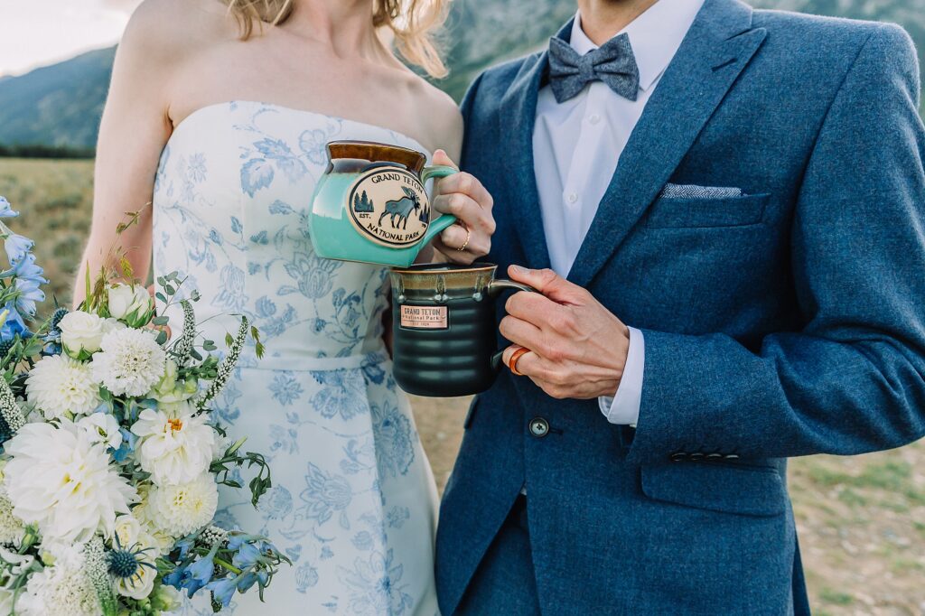 bride and groom hold special Grand Teton National Park and Jackson Hole coffee mugs