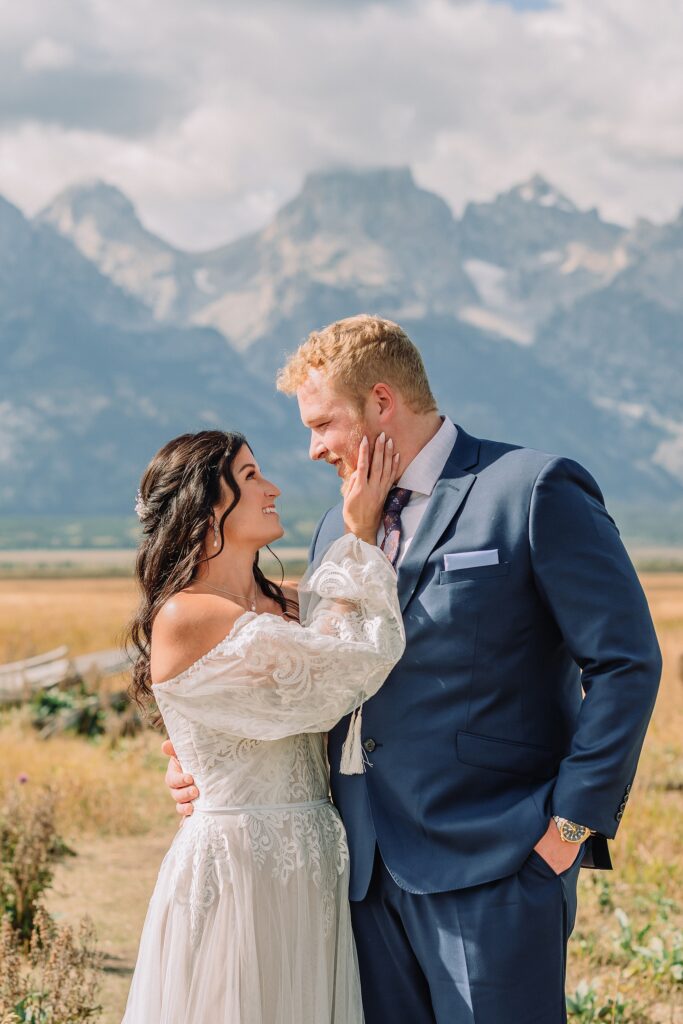 wedding couple poses romantically in front of mountain range