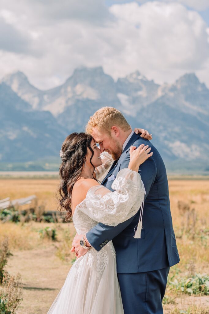 wedding couple poses romantically in front of mountain range