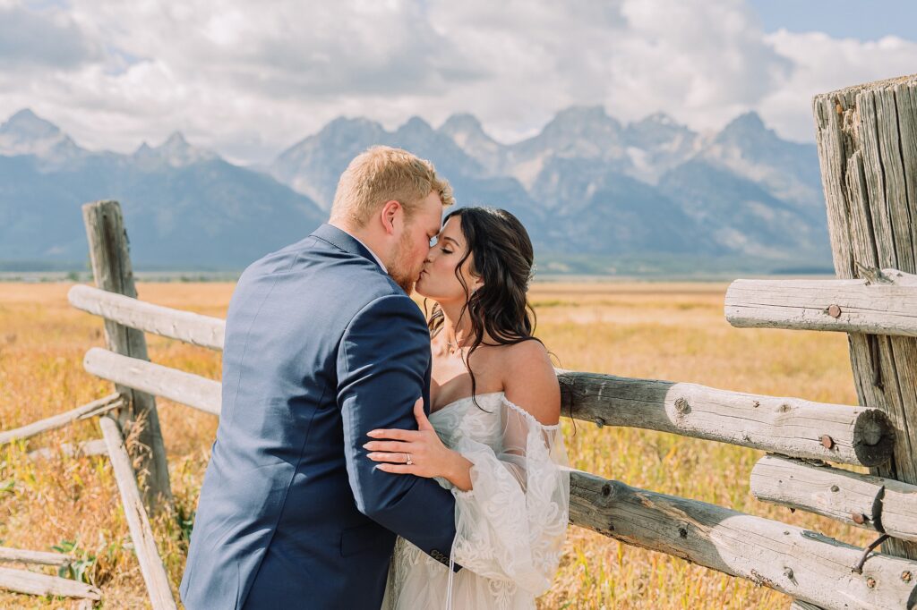 wedding couple poses romantically in front of mountain range