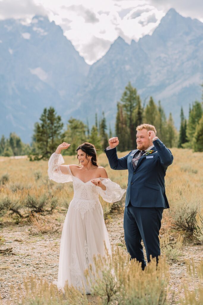 bride and groom celebrate their wedding ceremony at mountain view turnout with arms lifted