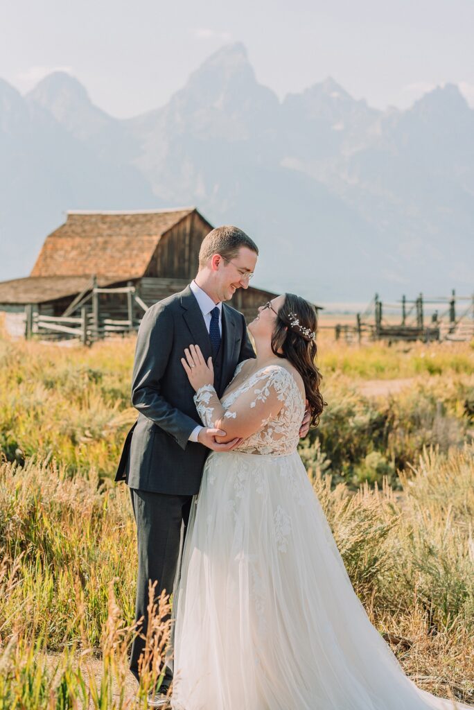 Jackson Hole wedding photographer barn photos Mormon Row western glam wedding dress deep neckline lace details mountain elopement with Teton backdrop intimate Jackson Hole wedding photography