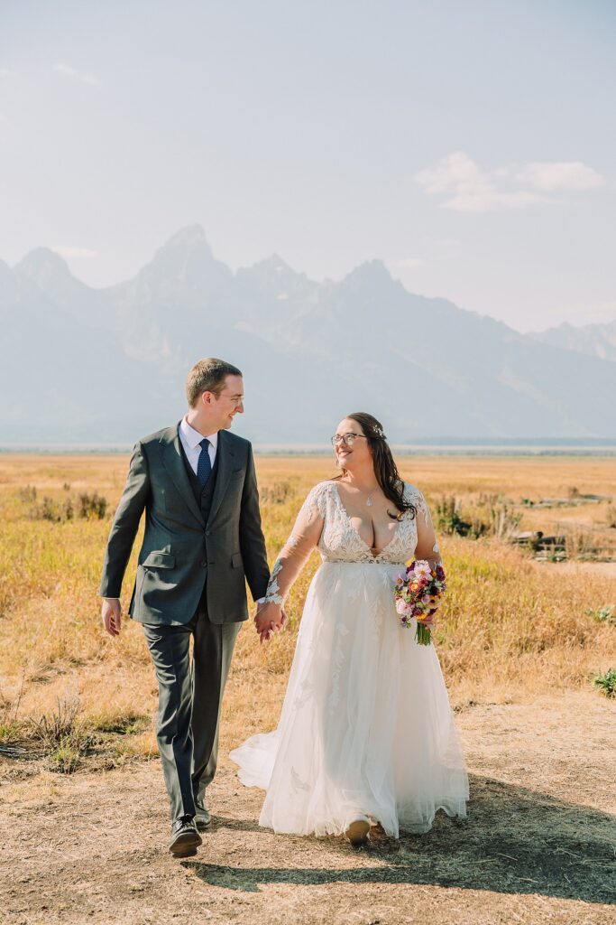 Mormon Row wedding portraits Jackson Hole bride in lace embroidered long sleeve wedding dress small intimate wedding ceremony ideas Mormon Row Grand Teton wedding ceremony