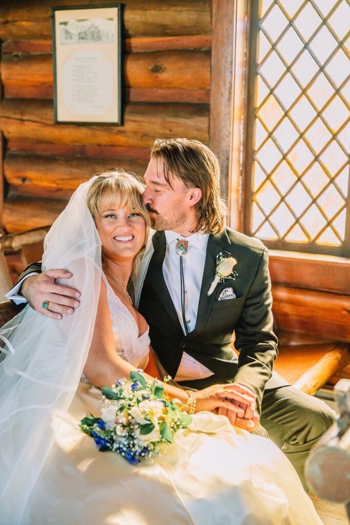 Grand Teton National Park micro wedding Chapel of the Transfiguration bride and groom portraits bride groom cowboy hat bolo tie mountain wedding Chapel of the Transfiguration bell ringing celebration Jackson Hole Wedding Photographers rustic chapel wedding log cabin ceremony