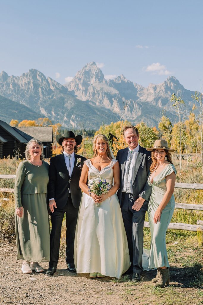 Grand Teton National Park micro wedding Chapel of the Transfiguration bride and groom portraits bride groom cowboy hat bolo tie mountain wedding Chapel of the Transfiguration bell ringing celebration Jackson Hole Wedding Photographers rustic chapel wedding log cabin ceremony