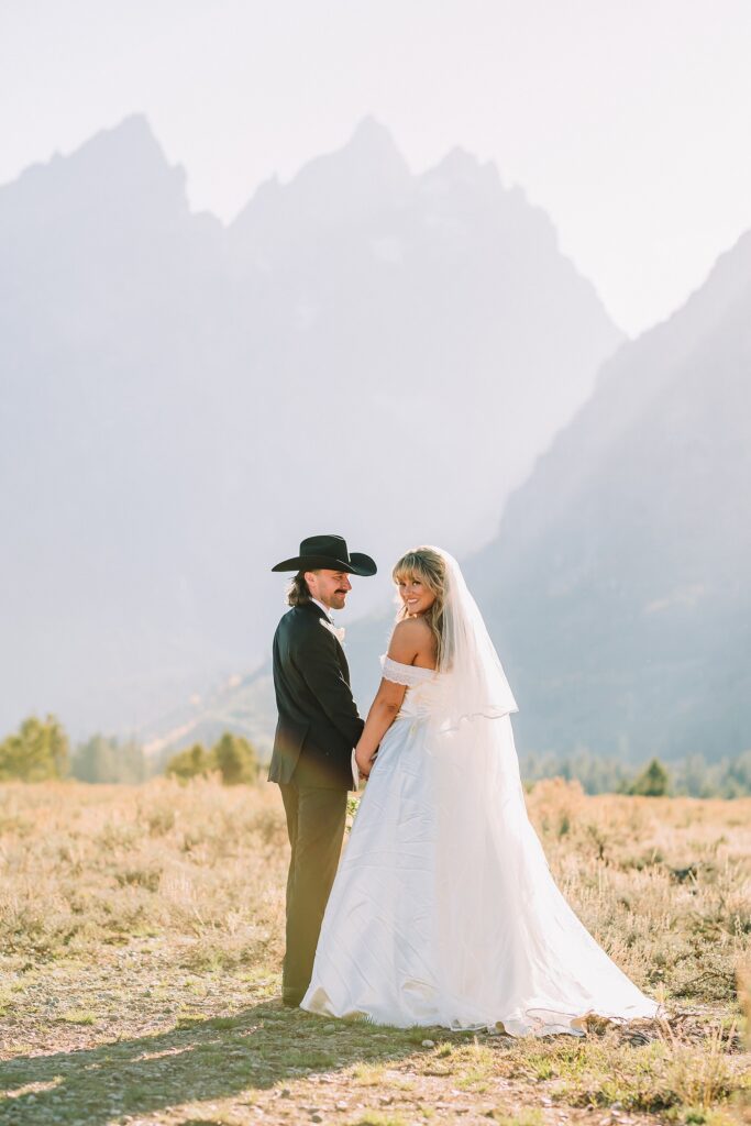 bride in mother's wedding dress teal boots bride groom cowboy hat bolo tie mountain wedding Cathedral Group Turnout wedding photos sagebrush String Lake wedding photography sunset late September wedding Grand Teton fall foliage