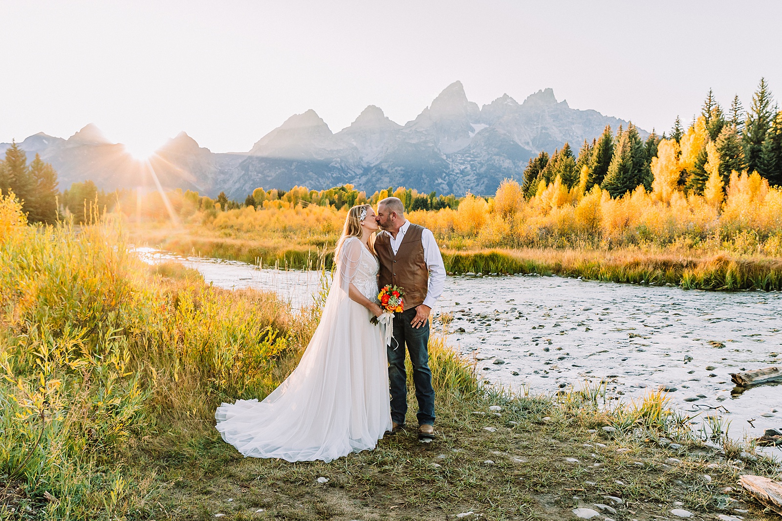Jackson Hole honeymoon wedding photos Schwabacher Landing wedding portraits Snake River wedding photography September mountain wedding photos beaded wedding dress golden hour western groom style wedding photos Teton mountain wedding portraits sheer cape wedding dress photography