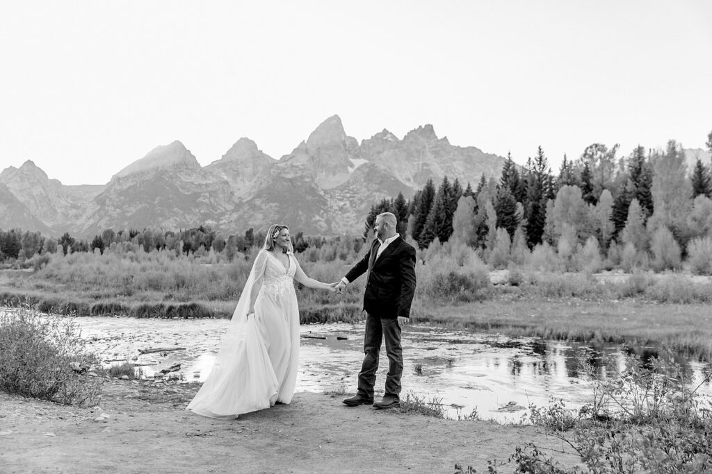 Jackson Hole honeymoon wedding photos Schwabacher Landing wedding portraits Snake River wedding photography September mountain wedding photos beaded wedding dress golden hour western groom style wedding photos Teton mountain wedding portraits sheer cape wedding dress photography
