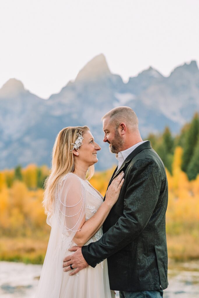Jackson Hole honeymoon wedding photos Schwabacher Landing wedding portraits Snake River wedding photography September mountain wedding photos beaded wedding dress golden hour western groom style wedding photos Teton mountain wedding portraits sheer cape wedding dress photography