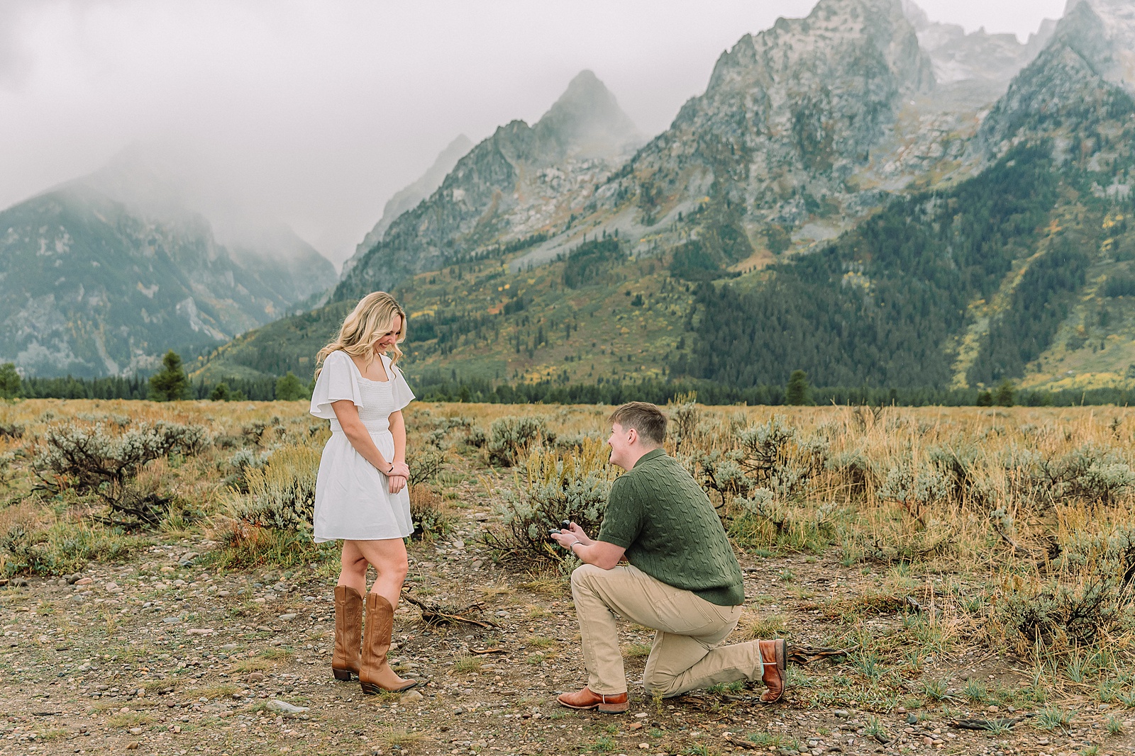 Grand Teton proposal photos at Cathedral View Turnout in the rain Cathedral View Turnout proposal photographer Jackson Hole Wyoming Genuine proposal reaction photos Grand Teton sagebrush field Moody stormy mountain proposal photography Jackson Hole jackson hole proposal photographer