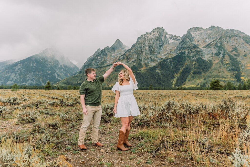 Grand Teton proposal photos at Cathedral View Turnout in the rain Cathedral View Turnout proposal photographer Jackson Hole Wyoming Genuine proposal reaction photos Grand Teton sagebrush field Moody stormy mountain proposal photography Jackson Hole jackson hole proposal photographer