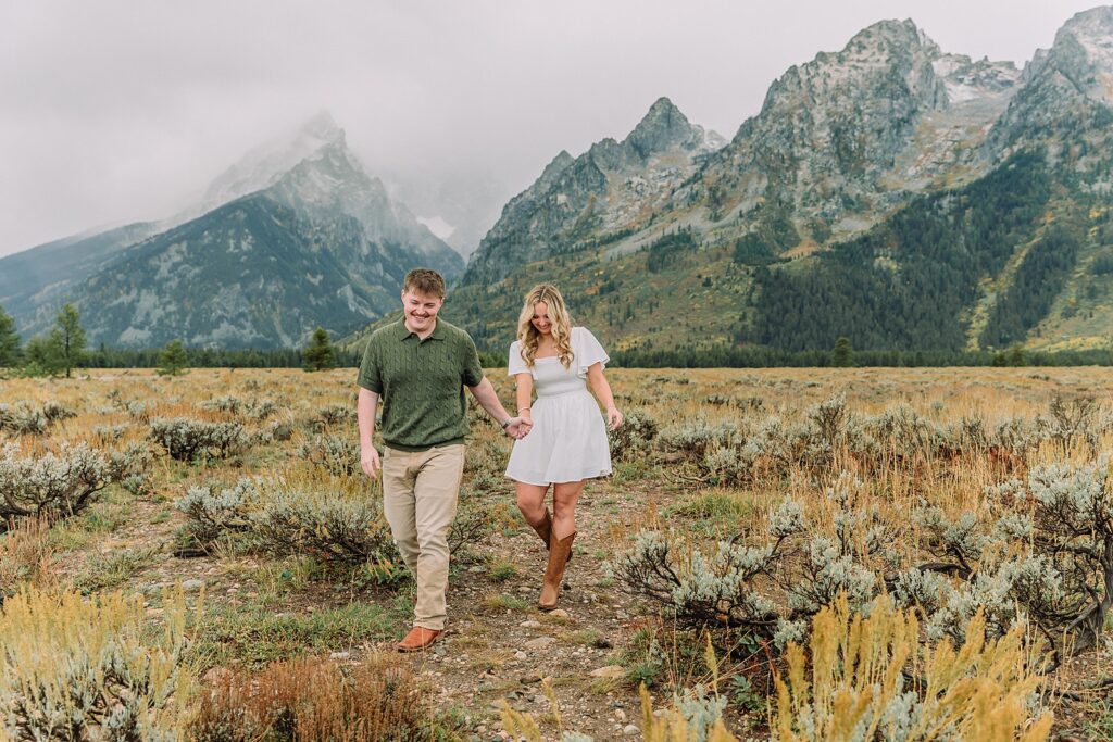 Grand Teton proposal photos at Cathedral View Turnout in the rain Cathedral View Turnout proposal photographer Jackson Hole Wyoming Genuine proposal reaction photos Grand Teton sagebrush field Moody stormy mountain proposal photography Jackson Hole jackson hole proposal photographer