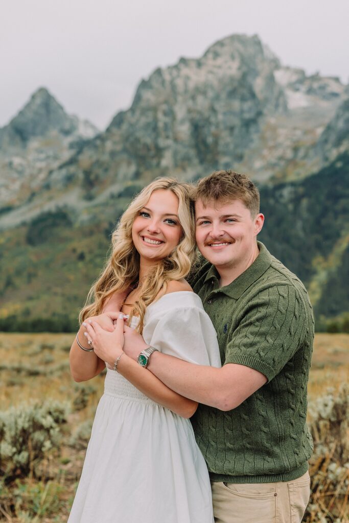 Grand Teton proposal photos at Cathedral View Turnout in the rain Cathedral View Turnout proposal photographer Jackson Hole Wyoming Genuine proposal reaction photos Grand Teton sagebrush field Moody stormy mountain proposal photography Jackson Hole jackson hole proposal photographer
