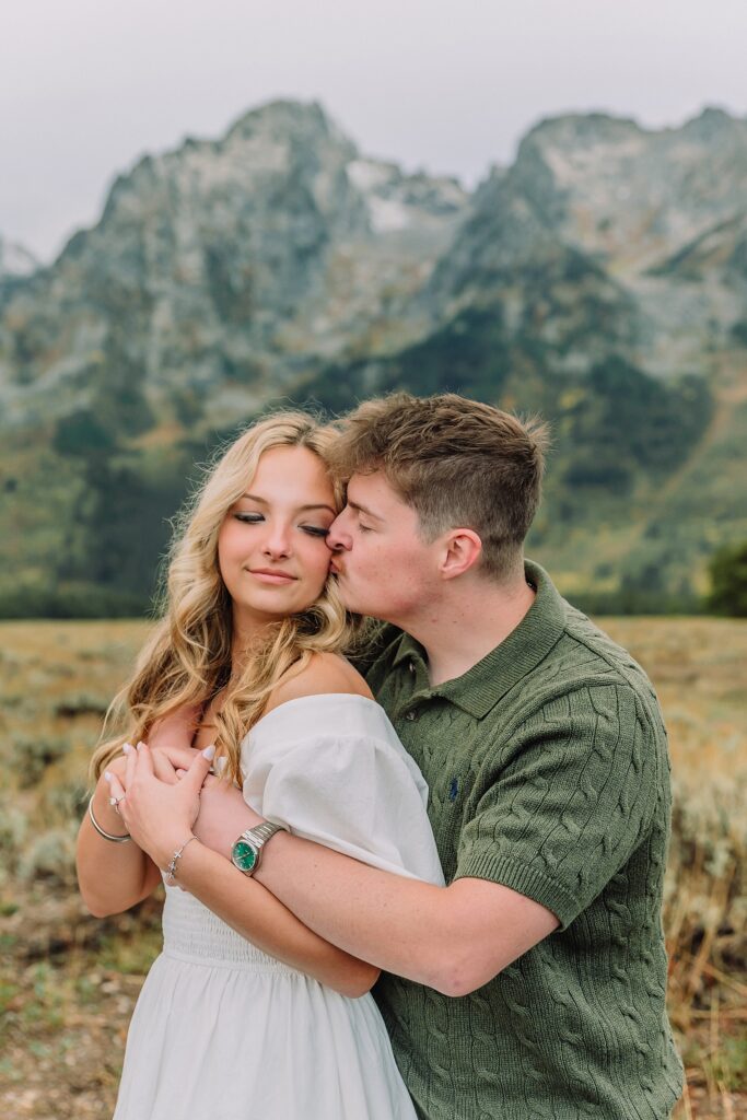 Grand Teton proposal photos at Cathedral View Turnout in the rain Cathedral View Turnout proposal photographer Jackson Hole Wyoming Genuine proposal reaction photos Grand Teton sagebrush field Moody stormy mountain proposal photography Jackson Hole jackson hole proposal photographer